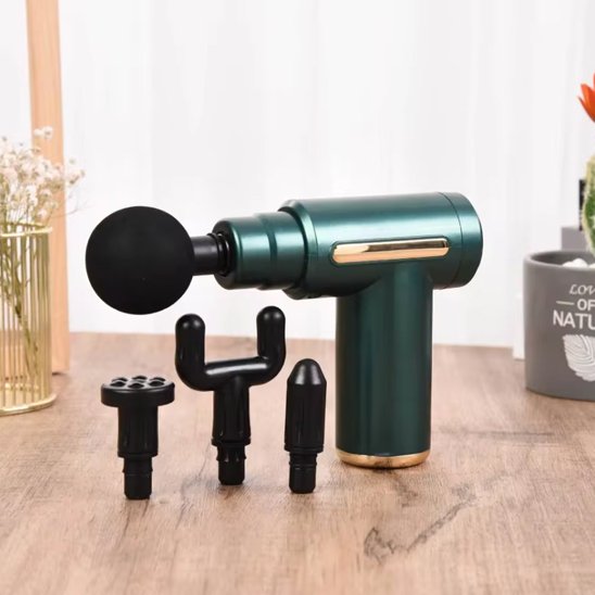 Pistolet de massage vert sur table de bois