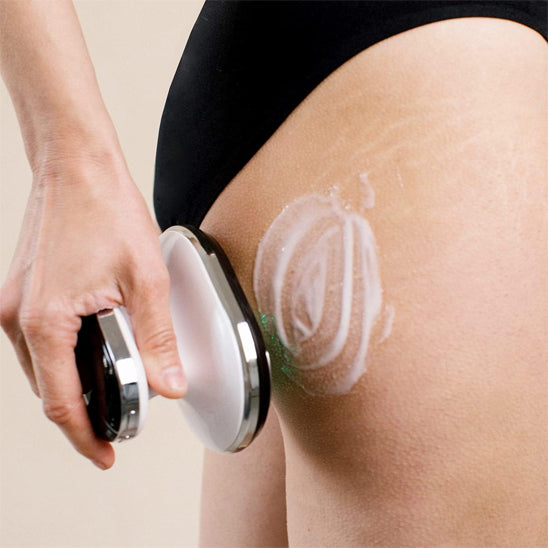 main sur appareil de massage sur la fesse avec  de la crème sur fond beige