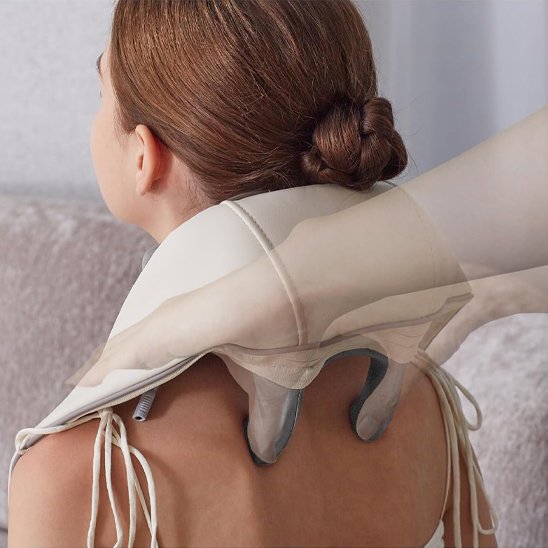  main sur appareil massage sur dos de femme les cordons blanc dans le salon flou