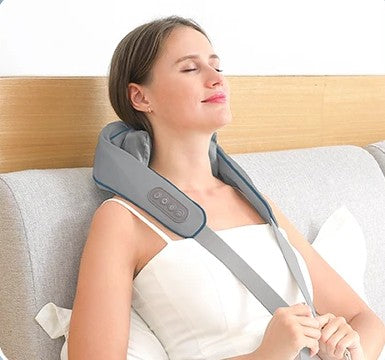 femme avec appareil massage  gris autour du cou dans la chambre a coucher 