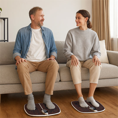 couple avec appareil massage pieds sur le sofa gris dans le salon