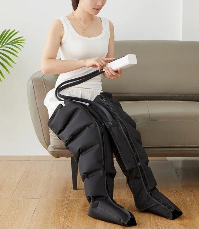 main de femme en camisole blanc bottes pressothérapie noir dans le salon