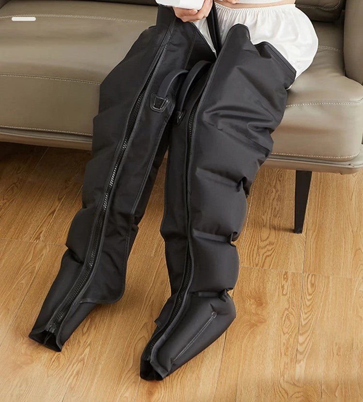 bottes de pressothérapie noir sur sofa brun  sur plancher de bois