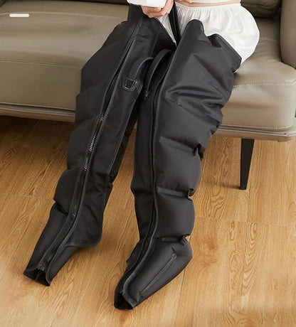 bottes de pressothérapie noir sur sofa brun  sur plancher de bois