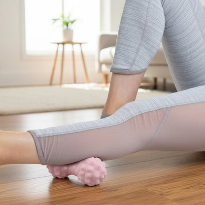 mollet  sur boule de massage rose sur le plancher de bois