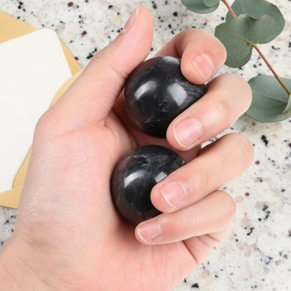 boule de massage noir dans la main sur comptoir de granit