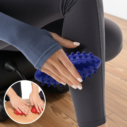 main roule boule de massage allonge sur jambe pantalon noir sur plancher de bois