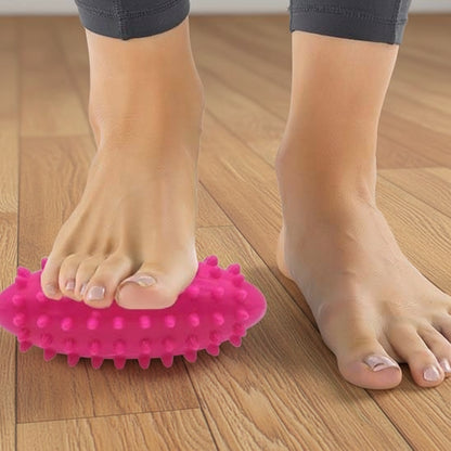 pied sur boule de massage rose sur plancher de bois