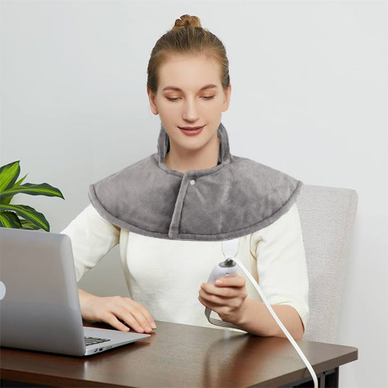femme avec coussin chauffant sur les épaules à son bureau