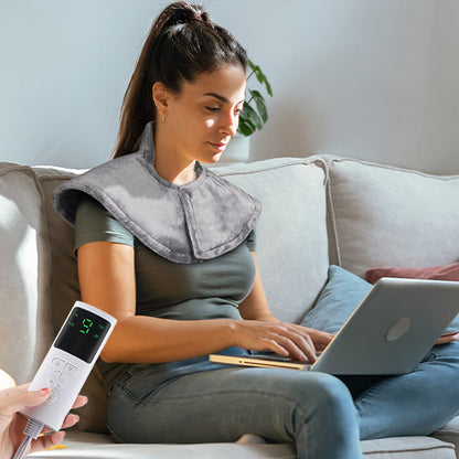 femme avec coussin chauffant sur les épaules assis dans le salon