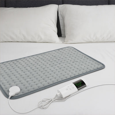 coussin chauffant sur lit blanc