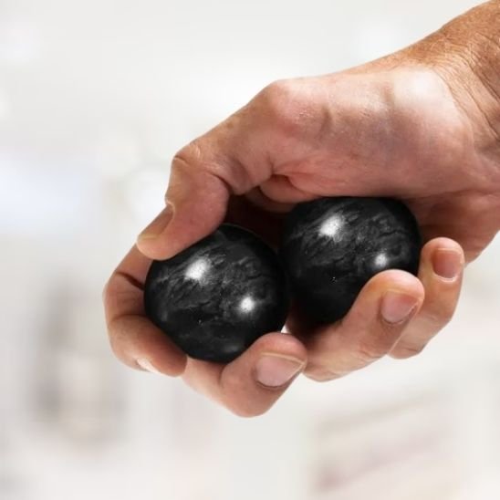 deux boule de massage noir main sur fond blanc