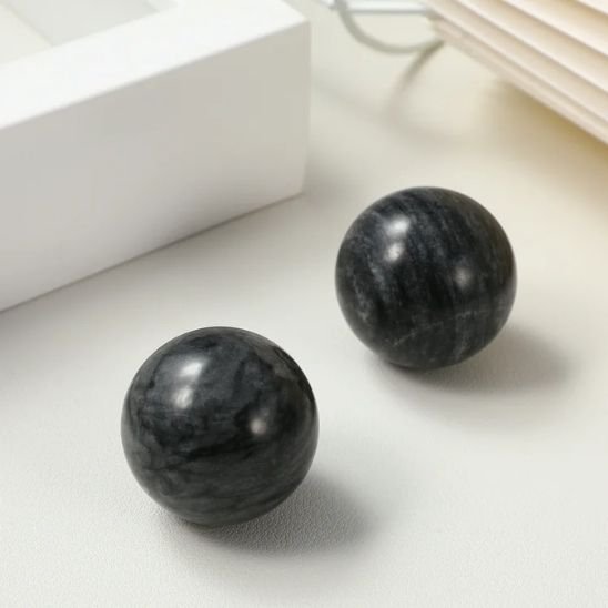 deux boule de massage noir sur fond blanc