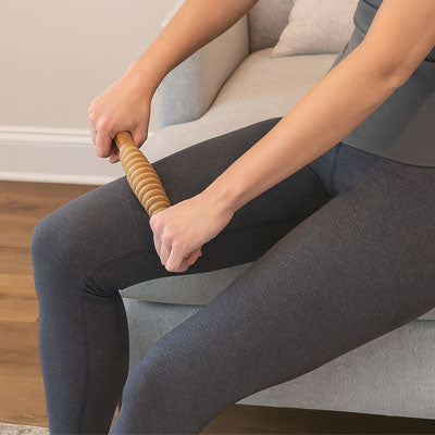 deux main sur rouleau de massage sur cuisse