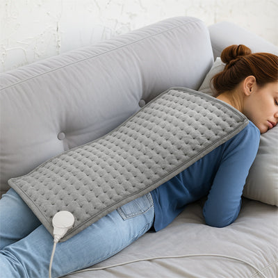 femme allonger sur sofa avec coussin chauffant sur dos