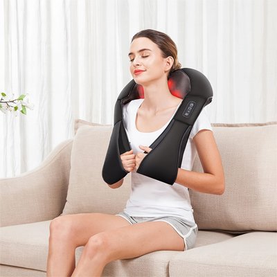 femme assis sofa blanc avec appareil de massage noir epaule
