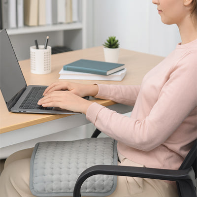 femme assis tape sur laptop avec coussin chauffant sur cuisse