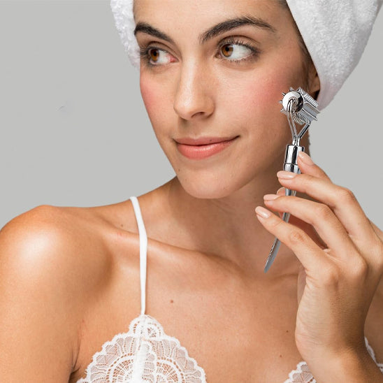 femme top blanc main elegante roule rouleau de massage argent sur joue