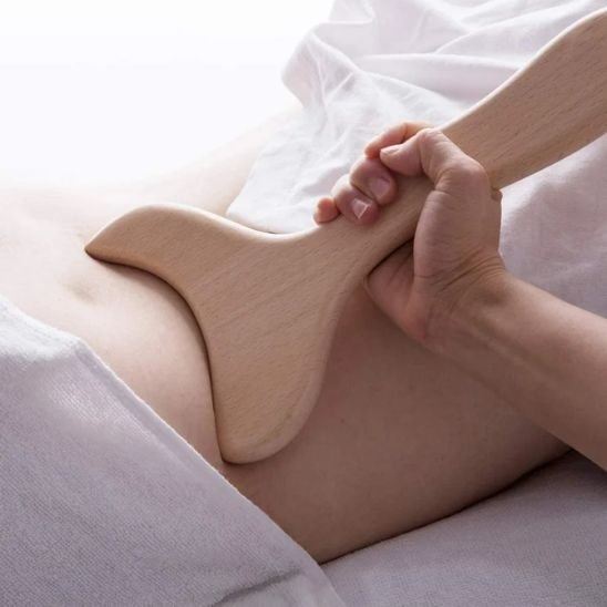 main sur gua sha sur dos dans salle de massage