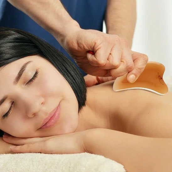 main sur gua sha grattoir sur sur dos de femme fond flou