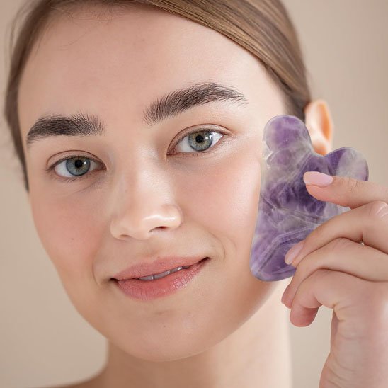 gua sha sur le visage fond beige