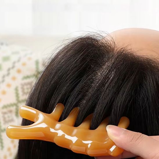 cheveux noir le pouce sur gua sha peigne dauphin sur fond flou