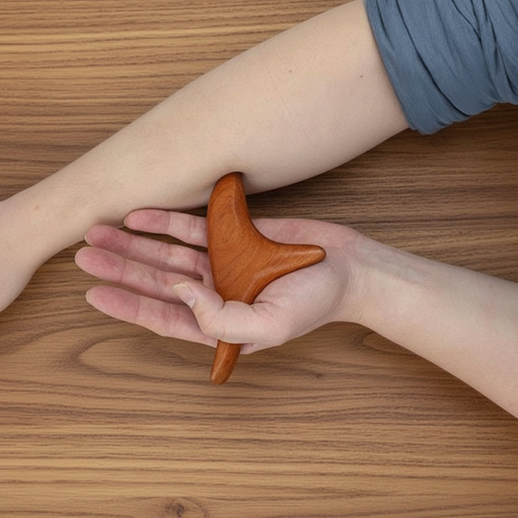 main sur gua sha sur avant bras sur table de bois