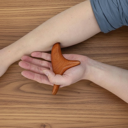 main sur gua sha sur avant bras sur table de bois