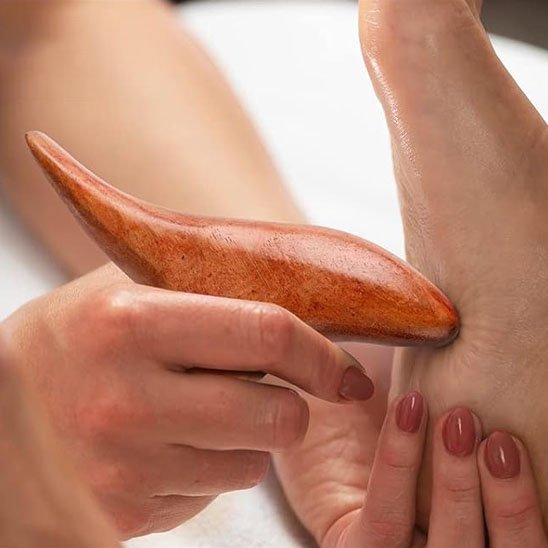 main sur gua sha sous fond blanc