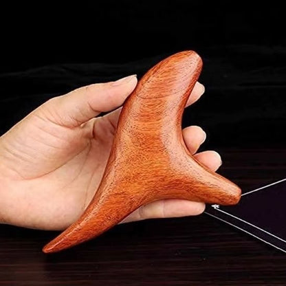 gua sha dans une main sur fond noir