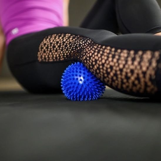 jambe pantalon noir sur boule de massage bleu