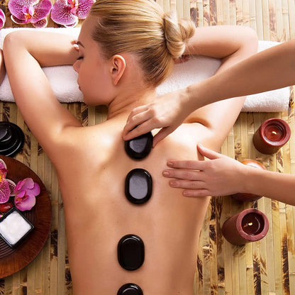 massage aux pierres chaudes sur le dos d'une femme sur du bambou 