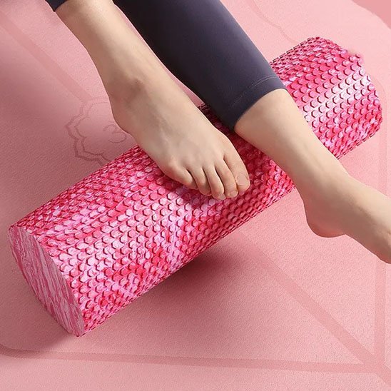 pied et mollet sur rouleau de massage rose