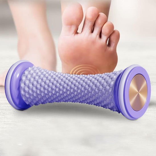 pied sur rouleu de massage violet sur plancher blanc