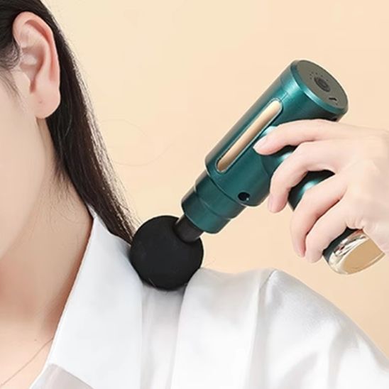 main de femme sur pistolet de massage vert sur fond beige