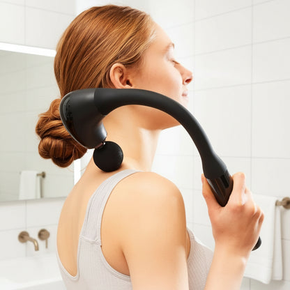 femme avec pistolet de massage sur l'épaule dans la salle de bain