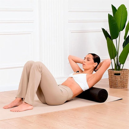 femme en top blanc rouleau de massage noir dans le salon