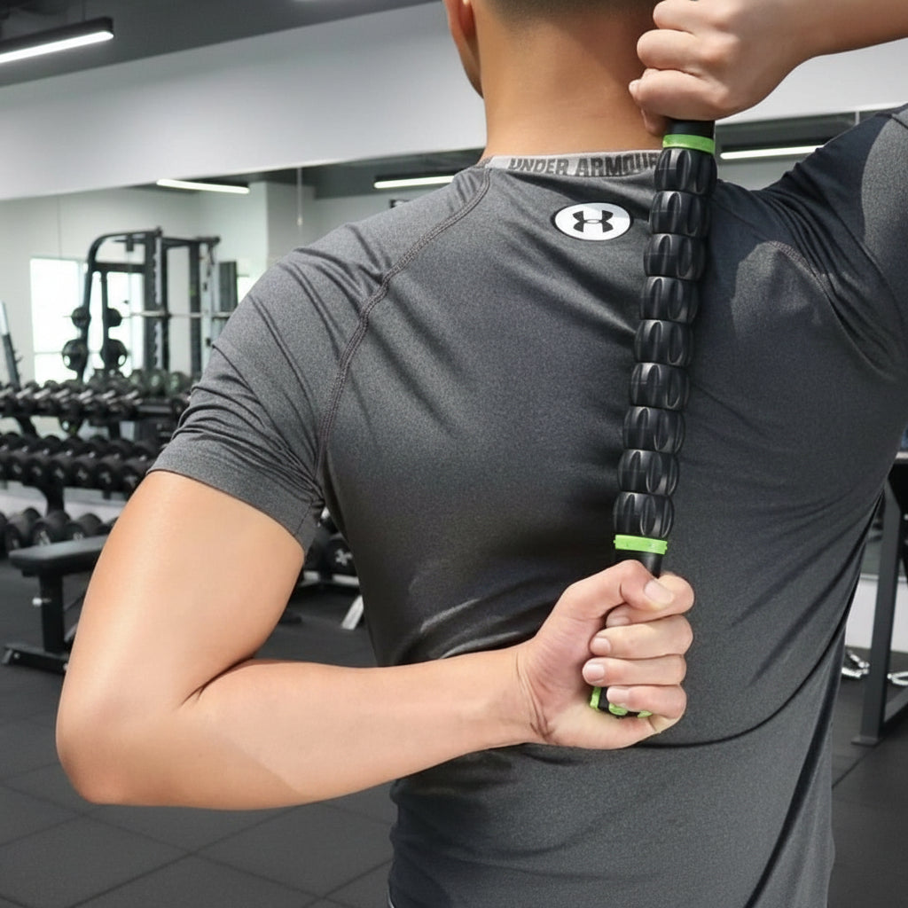 main d'homme en teeshirt gris rouleau de massage noir dans salle de gymnase