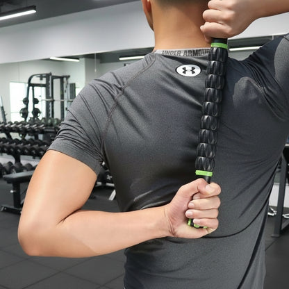 main d'homme en teeshirt gris rouleau de massage noir dans salle de gymnase