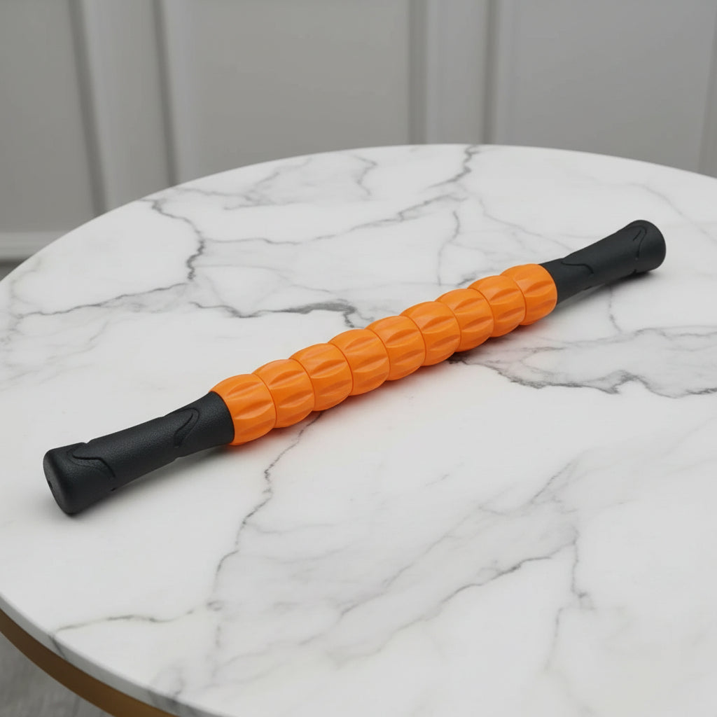 rouleau de massage orange et noir sur une table de marbre