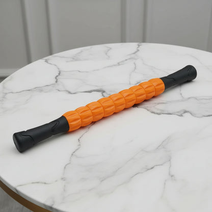 rouleau de massage orange et noir sur une table de marbre