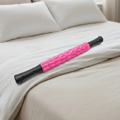 rouleau de massage rose et noir sur un lit de chambre