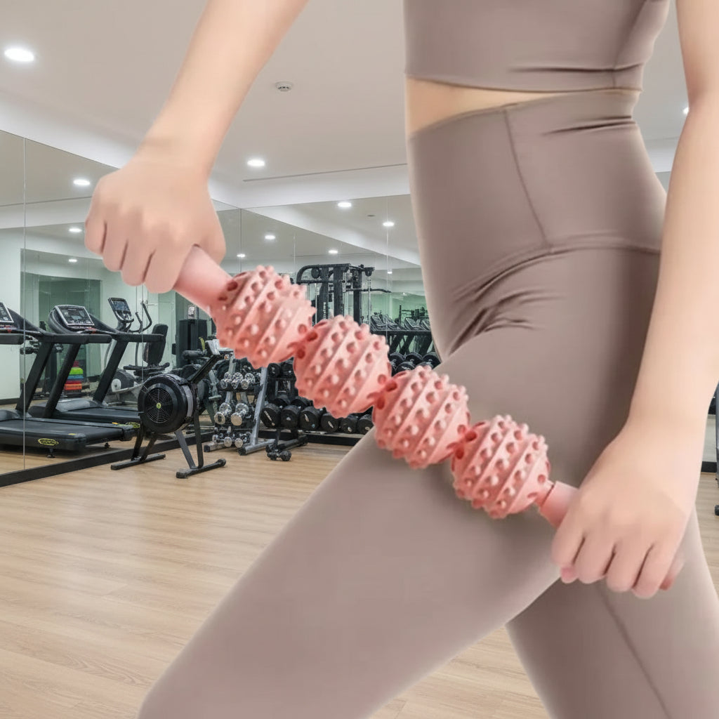 femme pantalon gris roule rouleau de massage rose sur la cuisse dans un salle de gymnase