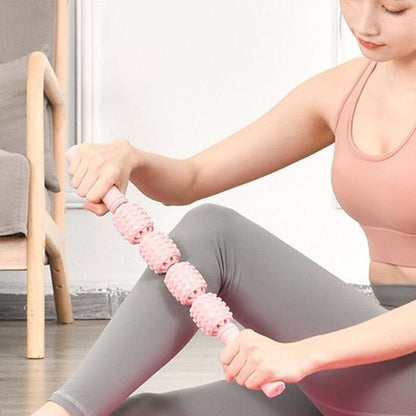 femme en camisole rose avec rouleau de massage sur genou pantalon gris dans le salon