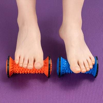 pied sur rouleau de massage orange et l'autre pied sur rouleau de massage  bleu sur tapis violet