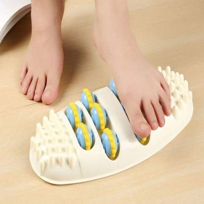 le pied sur rouleau de massage sur plancher de bois brun pale