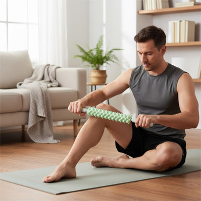 homme en camisole gris avec rouleau de massage vert dans le salon