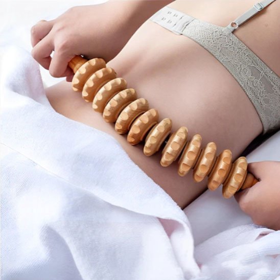 main sur rouleau de massage sur une femme dans un salon de massage