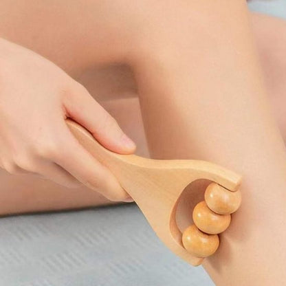 Main sur rouleau de massage en bois lisse sur jambe et mollet fond flou