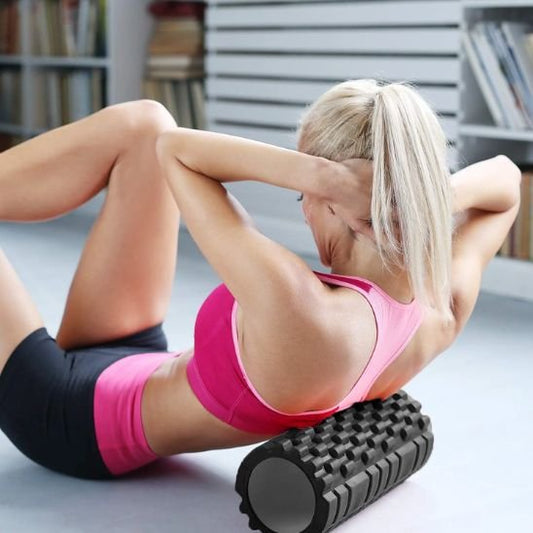 Femme en camisole rose rouleau massage noir fond flou